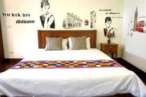 台南的住宿－台南益家客棧 ，卧室配有一张壁挂式海报的床