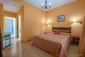 ラ・アルベルカにあるHotel Las Batuecasのベッドルーム1室(ベッド1台、シャンデリア付)