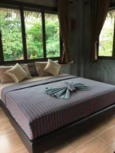 a bed in a bedroom with two towels on it at Thai Terrace Bungalow in Thong Nai Pan Yai