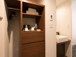 a bathroom with a cabinet with a sink at S.Training Center Hotel Osaka in Osaka