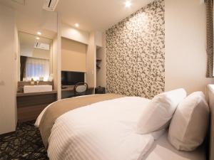 a hotel room with a bed and a bathroom at S.Training Center Hotel Osaka in Osaka