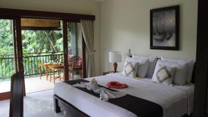 - une chambre avec un grand lit et des serviettes dans l'établissement Ketut Kasta Guest House, à Ubud