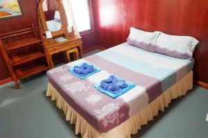 a bedroom with a bed with towels on it at Harmony House-SHA Plus in Phi Phi Islands