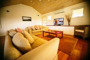 una sala de estar con un sofá y una mesa en Rayville Boat Houses, en Apollo Bay