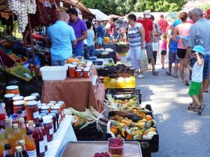 una folla di persone in un mercato all'aperto con frutta e verdura di Éva Apartman a Fonyód
