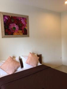 um quarto com uma cama com um quadro na parede em The Nine Mansion em Ubon Ratchathani