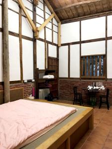 ein Schlafzimmer mit einem Bett in einem Zimmer mit Fenstern in der Unterkunft Bamboo House in Zhushan
