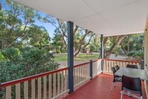 a screened porch with a table and chairs on it at Discovery Parks - Woodman Point in Coogee