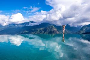 a man standing on a pole in the middle of a lake at Topas Ecolodge in Sapa