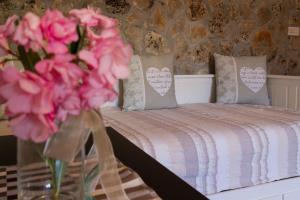 a bedroom with a bed with pink flowers in a vase at Apartmani Maksan in Pakoštane