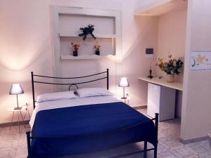 una camera da letto con letto con lenzuola e fiori blu di CaToledo a Napoli
