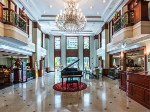 a grand lobby with a piano in the middle at Evergreen Laurel Hotel Bangkok in Bangkok