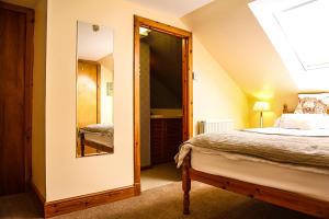 a bedroom with a bed and a large mirror at Henshire B&B in Dingwall