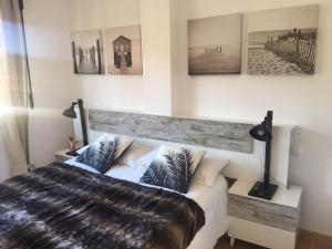 una camera da letto con un letto e alcuni quadri sul muro di Apartamento Ezcaray con Piscina a Zorraquín Altre 24 foto