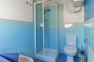 a blue bathroom with a toilet and a shower at Casa Cabrera in Pozzallo +13 photos