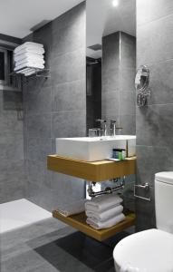 a bathroom with a toilet, sink, and bathtub at Hotel Val Convention in Nigrán
