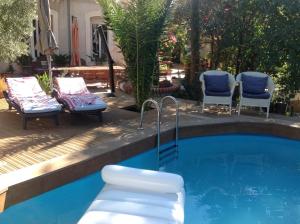 a swimming pool with two chairs and a table at A l'ombre du cedre in Hyères