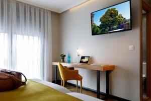 a hotel room with a desk and a laptop on a wall at Hotel Val Convention in Nigrán