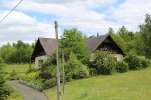 uma casa numa colina ao lado de uma estrada em Ferienwohnung Weitblick em Katzwinkel