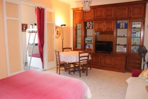 a bedroom with a table and chairs and a television at Appartamenti Lascaris in Lascari