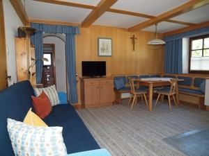 a living room with a blue couch and a table at Beilelers Hof in Arzl im Pitztal