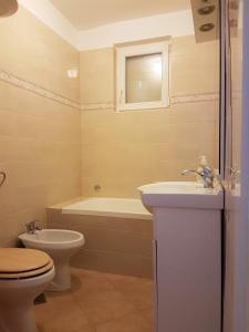 a bathroom with a toilet and a sink and a tub at Apartmani Ljerka Malinska in Malinska +54 photos