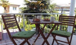 einen Holztisch und zwei Stühle auf dem Balkon in der Unterkunft Apartment Tip Top in Rovinj