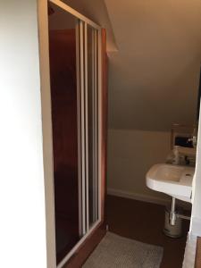 een badkamer met een douche en een wastafel bij Eeuwenhout vakantiedomein in Dranouter