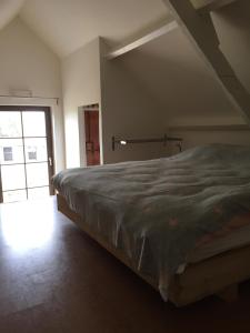 een slaapkamer met een groot bed in een kamer bij Eeuwenhout vakantiedomein in Dranouter