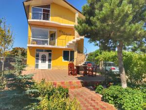 a yellow house with a table in front of it at Complex Scorpion in 2 Mai