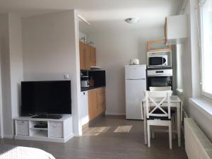 eine Küche mit einem TV und einem Tisch mit einem Stuhl in der Unterkunft City Apartment Maaherrankatu in Kuopio