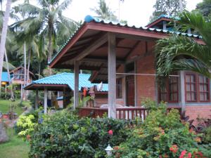 a brick house with a porch in a garden at Hanalei Gardens in Mae Nam