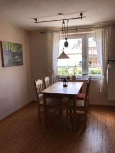 a dining room with a table and chairs and a window at Ferienwohnung Schlössershof in Borler