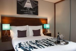 a bedroom with a large bed with two lamps at Nations Porto - Studios & Suites in Porto