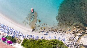 an aerial view of a beach with umbrellas and the ocean at Hotel Dei Pini in Alghero