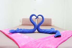 two blue towels on top of a bed at Harmony House-SHA Plus in Phi Phi Islands