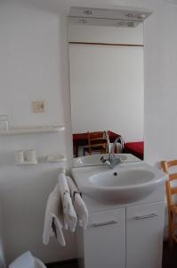 een witte badkamer met een wastafel en een spiegel bij Hotel Cafe 't Zonneke in Oosterhout