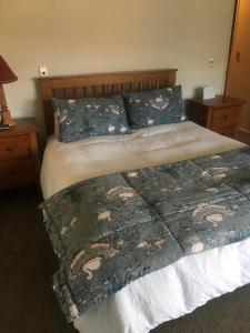 a bedroom with a bed with a blanket and pillows at Luxury on Lakeside in Wanaka
