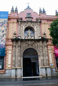 un grand bâtiment rose avec une grande porte dans l'établissement Céntrico Apartamento con Patio Privado, à Séville