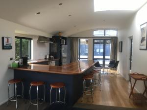 a kitchen with a counter and bar with stools at Luxury on Lakeside in Wanaka