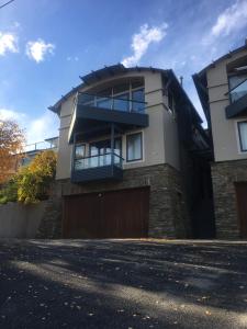 a large house with a garage in front of it at Luxury on Lakeside in Wanaka