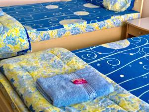 バンコクにあるTat Hotelのベッド2台、ソファ、枕が備わる客室です。
