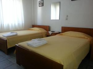 two beds in a hotel room with towels on them at Efstathiou Mihail Studios and Apartments in Stómion +73 photos