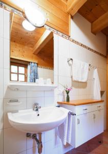 a bathroom with a white sink and wooden ceilings at ÖKO Feriendorf Schlierbach in Schlierbach