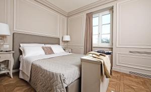 a white bedroom with a bed and a window at Le Selve Lake View Villas in Toscolano Maderno
