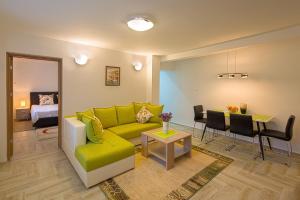 a living room with a green couch and a dining room at Apartment Mistovic in Kotor