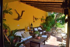 un patio con sofás, mesas y macetas en Casa Rural Don Álvaro de Luna en Don Álvaro