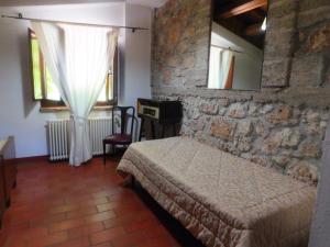 1 dormitorio con cama y pared de piedra en La Locanda sul Lago, en Santo Stefano di Sessanio