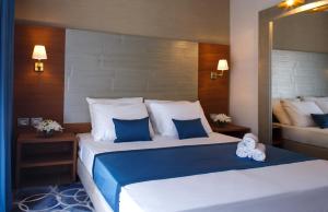 a bedroom with two beds with blue and white pillows at Medi Terre Boutique Hotel - By Saida Hotels in Netanya
