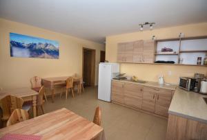 a kitchen and dining room with a table and a refrigerator at Vila Kamah in Vysoke Tatry - Tatranska Lomnica.